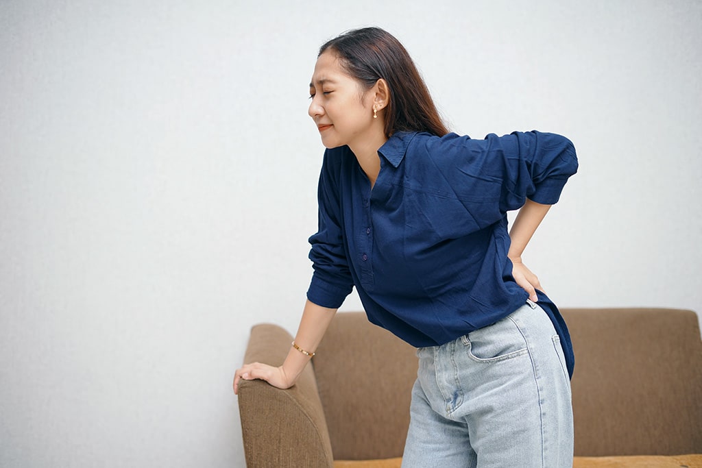 A young lady experiencing spine-related back pain.