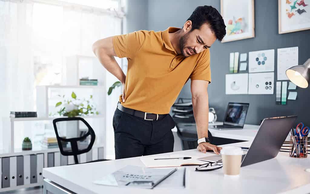 Man holding his lower back due to slipped disc pain.