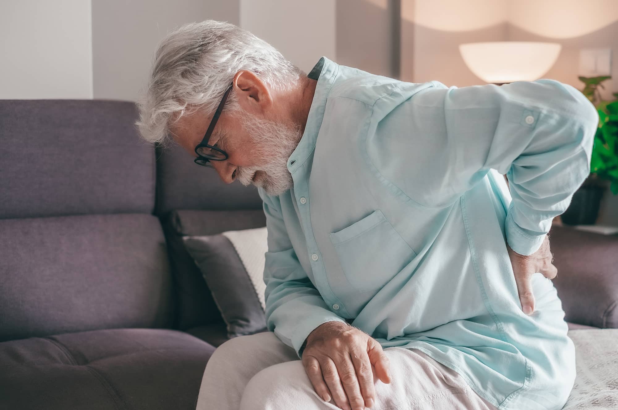 Senior elder man feel sudden back pain muscles ache tension injury at home, sad old grandfather touching spine having lower lumbago backache osteoarthritis arthritis, backache concept