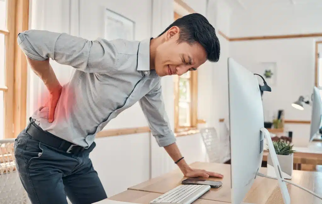 Businessman with back pain at his desk