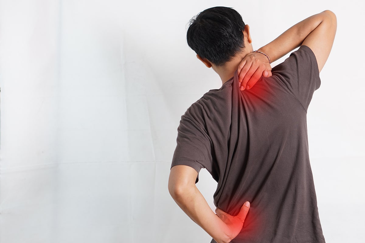 A man displaying signs of back and neck pain