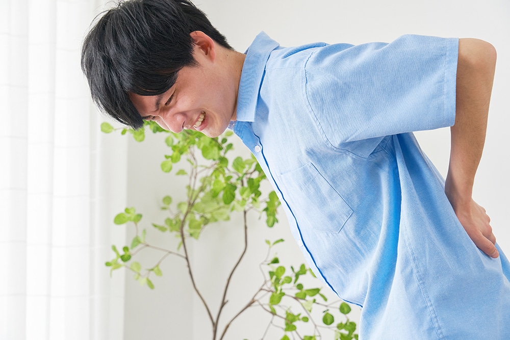 A man suffering from back pain due to a herniated disc