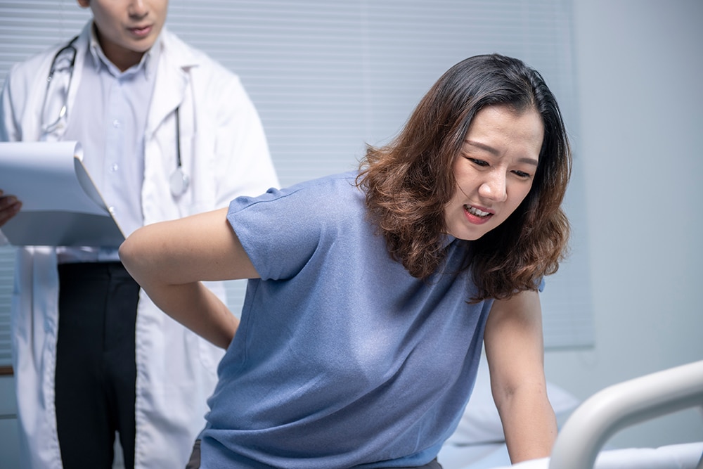 A woman seeking specialist care for lumbar spinal stenosis