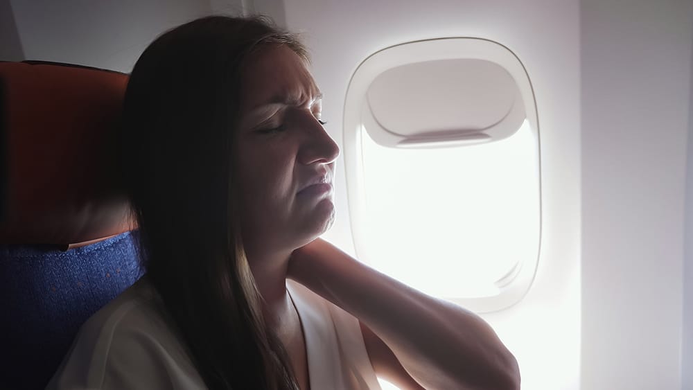 Female patient with cervical spondylosis, experiencing neck discomfort on her flight.