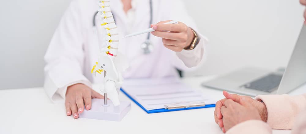 Spine specialist explaining about cervical spinal stenosis surgery to a patient.