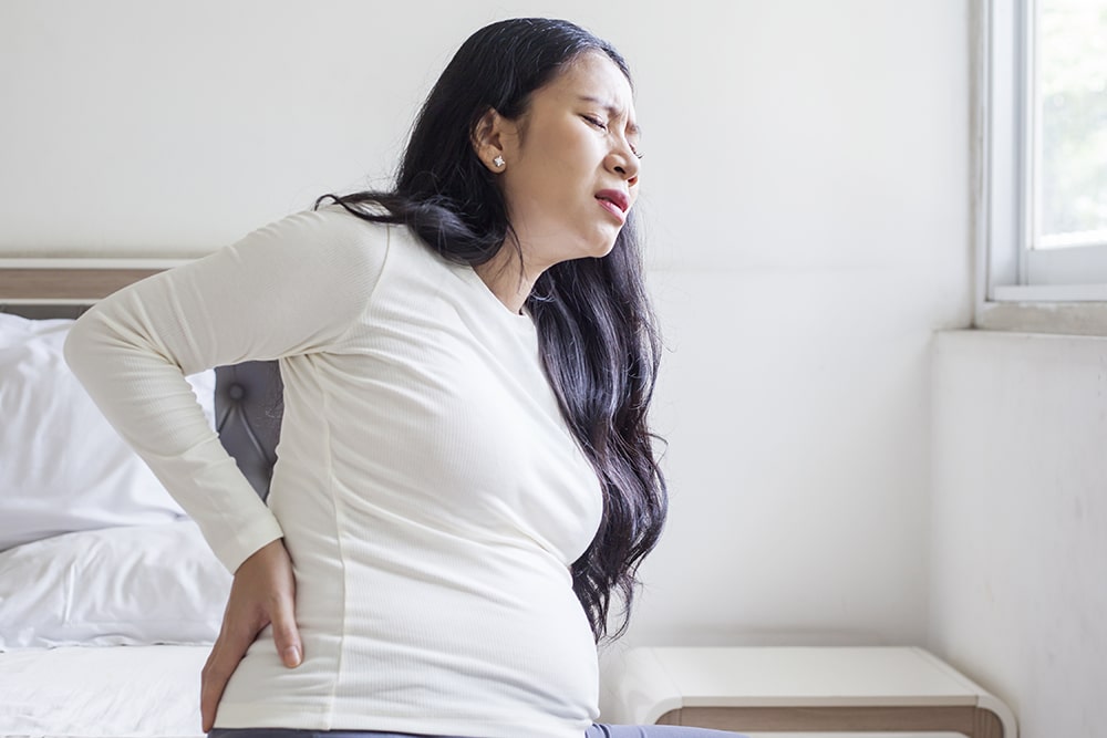 Expectant woman experiencing sciatica pain during her pregnancy.
