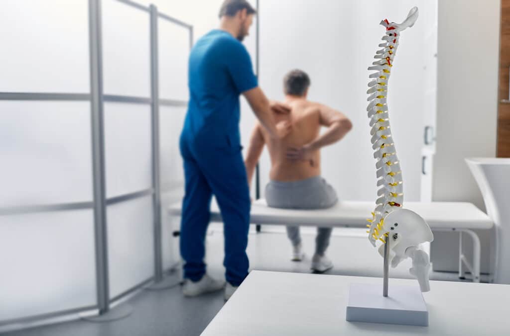 Doctor assessing patient’s spine