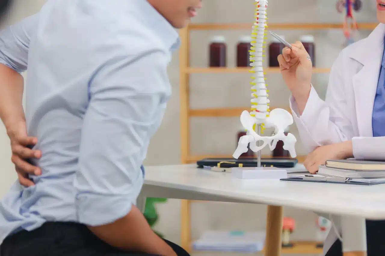 Slipped disc specialist consultation with a lumbar spine model