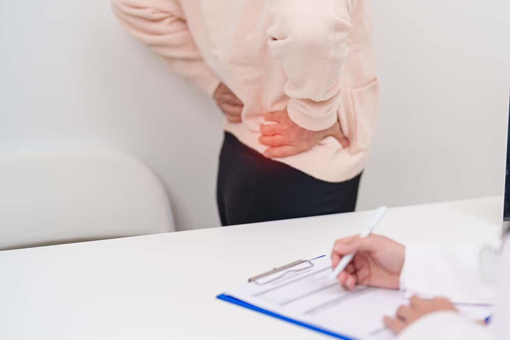 Patient receiving advice on lumbar spondylosis treatment during a spine consultation.