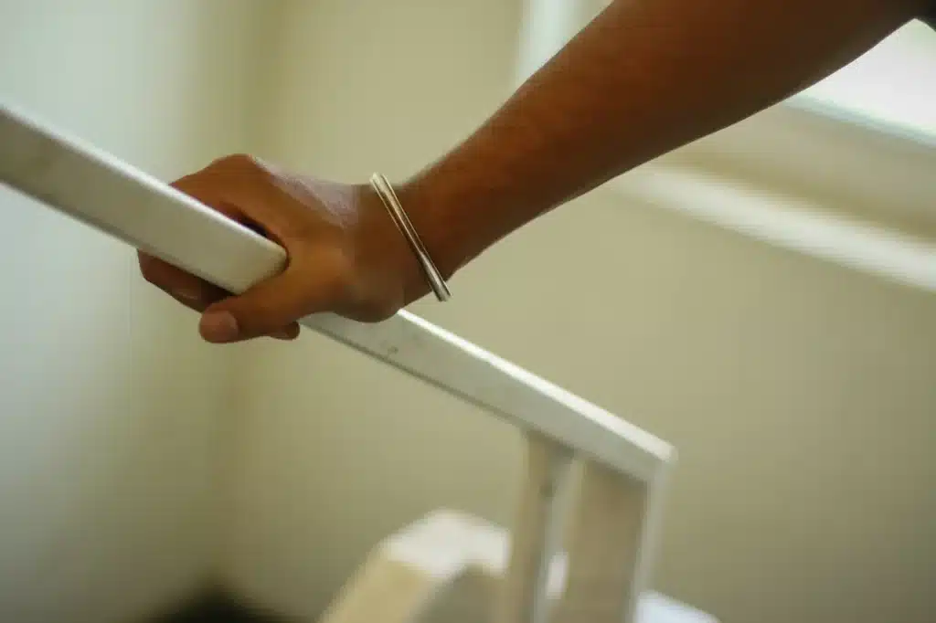 Man holding handrail while climbing stairs