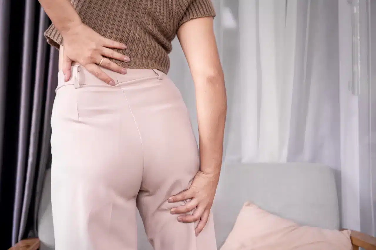 Woman touching her lower back and upper hamstring