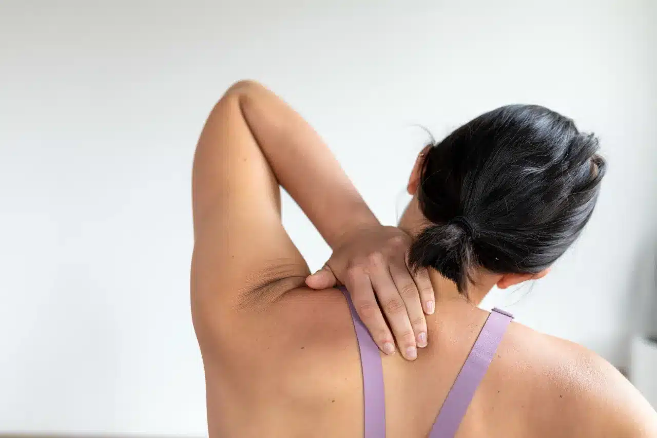 Person holding the back of their neck
